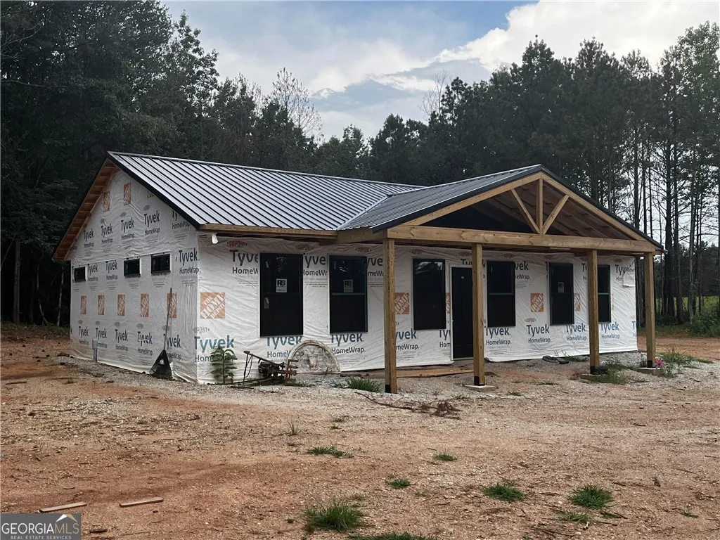 A new build with a metal roof and inviting porch awaits customization.