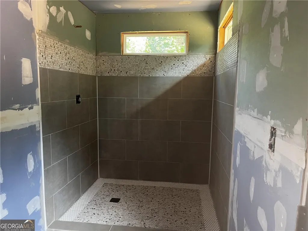 A newly tiled shower enclosure awaits its finishing touches, promising a fresh, revitalized space.