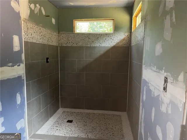 A newly tiled shower enclosure awaits its finishing touches, promising a fresh, revitalized space.