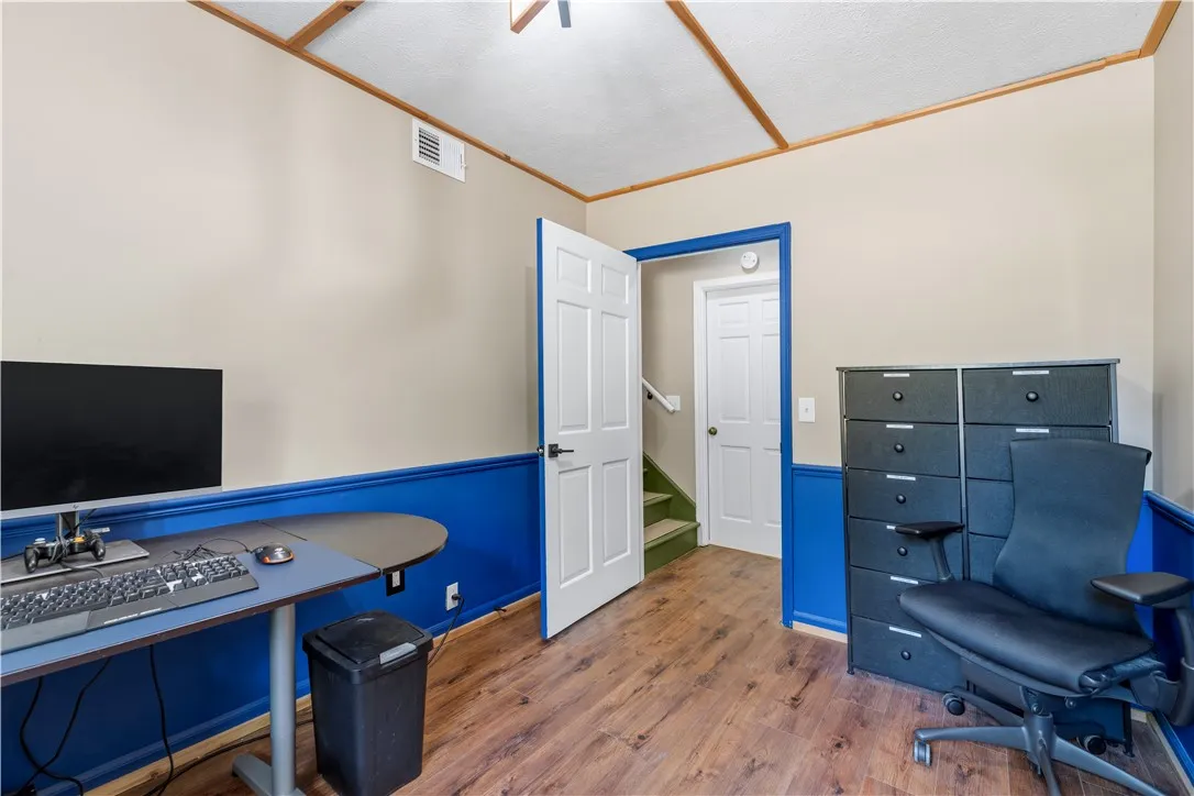 Hardwood-style flooring extends through this versatile room, ideal for a home office or creative space.
