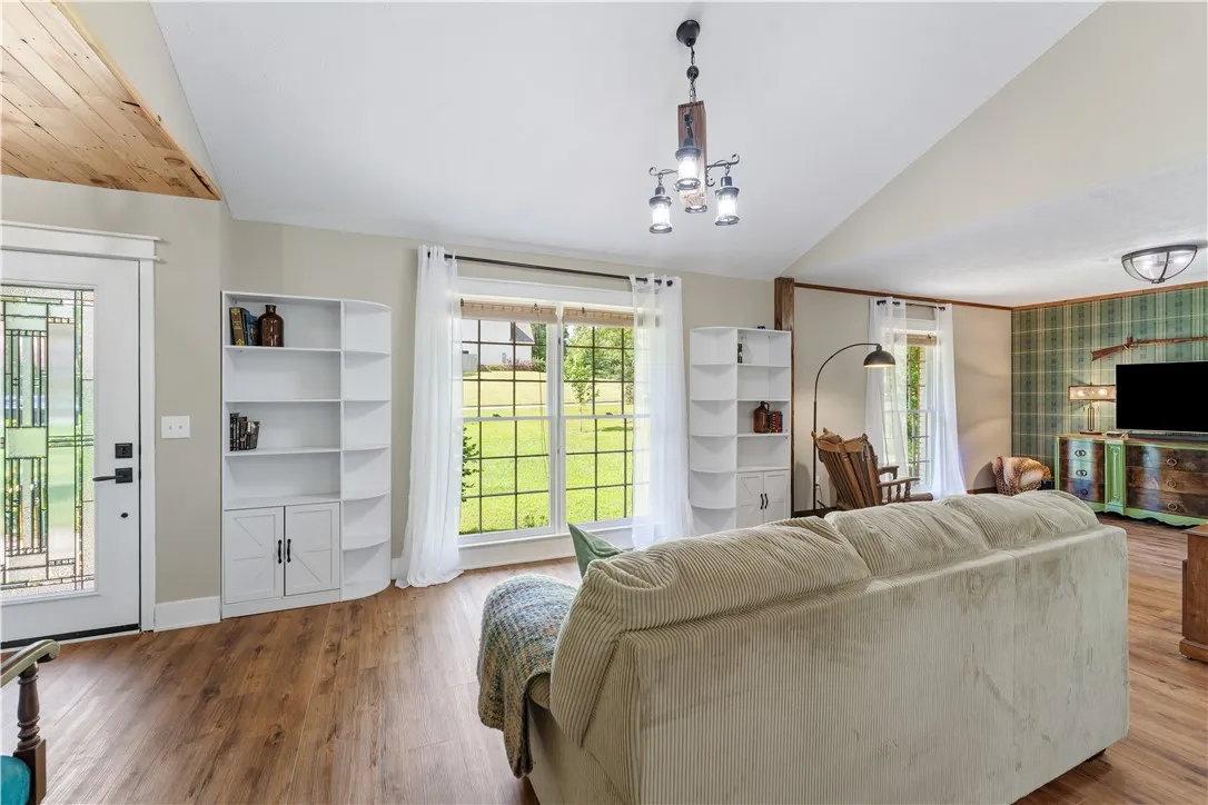 Natural light floods this living space, highlighting its vaulted ceilings and durable wood flooring.