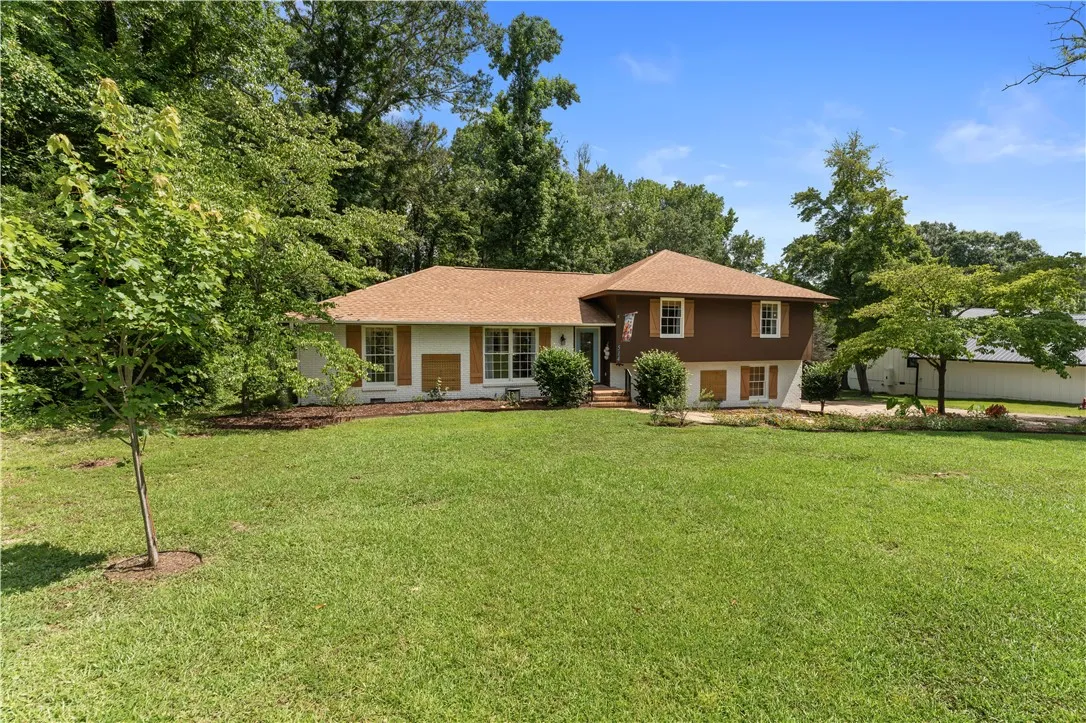 A classic facade with contrasting colors provides a welcoming presence set against a lush, green landscape.