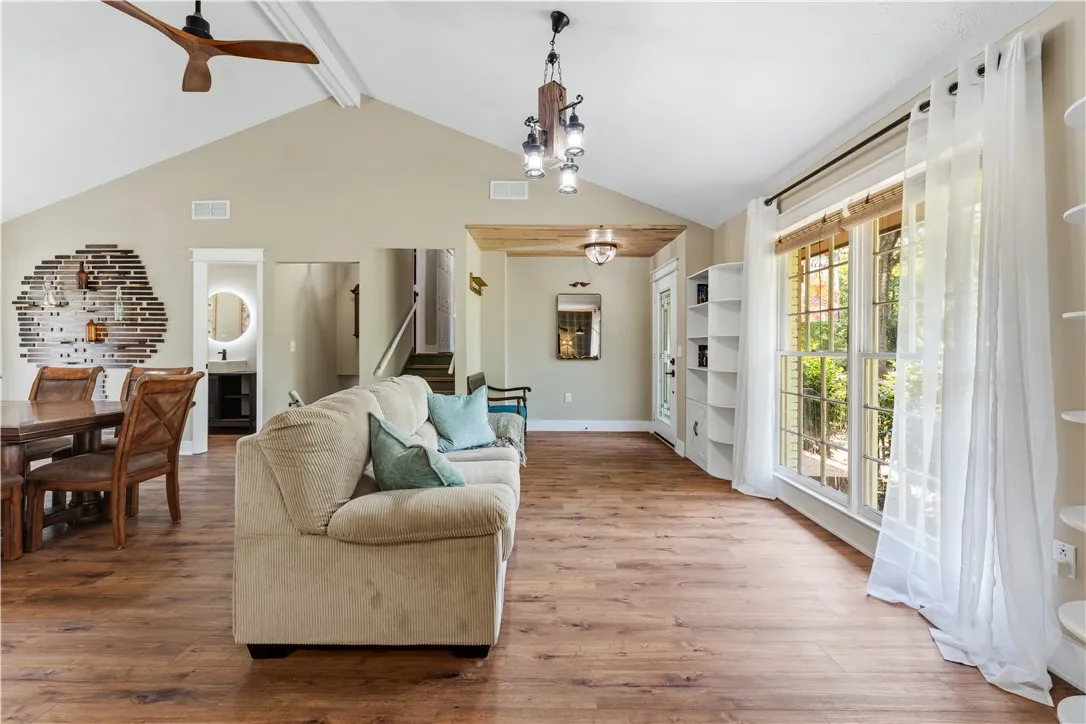 Vast vaulted ceilings and rich wood flooring create an inviting atmosphere in this luminous living area.