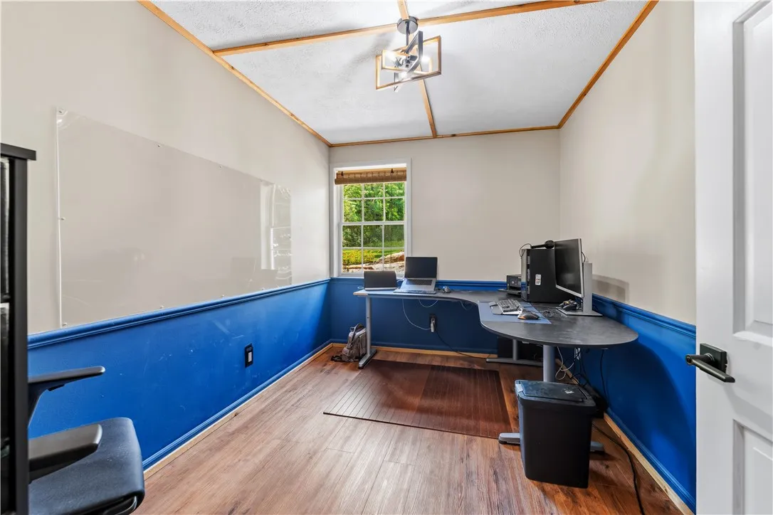 A dedicated home office space with rich wood flooring and a refreshing outdoor view.