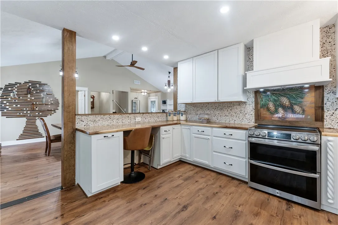 A well-appointed kitchen features rich hardwood flooring and sleek white cabinetry, offering both style and utility.