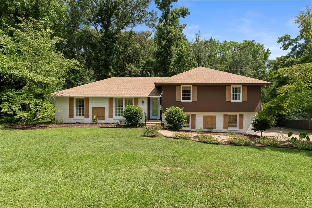 A well-maintained lawn welcomes you to this charming home, embraced by mature trees and verdant landscaping.