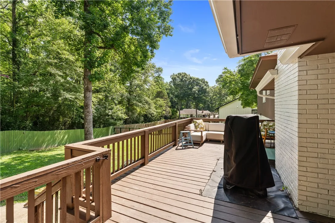 A spacious wooden deck provides ample outdoor living with lush backyard views.