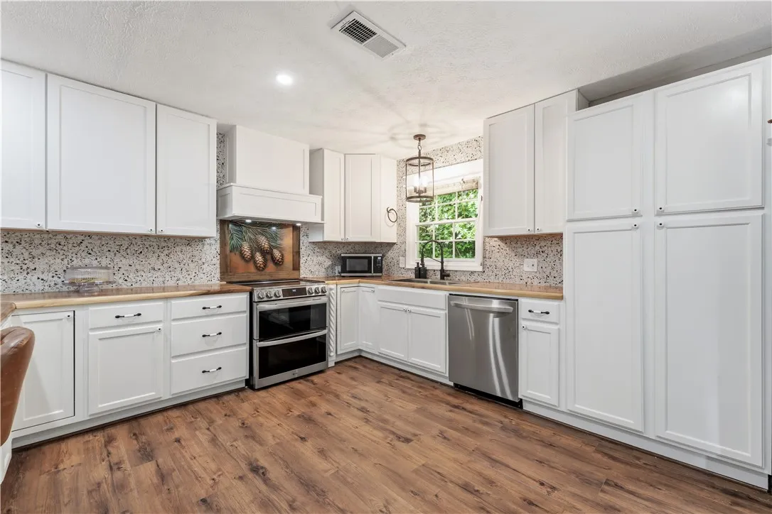Culinary aspirations come alive in this well-appointed kitchen, featuring a full suite of appliances and wood-style flooring.