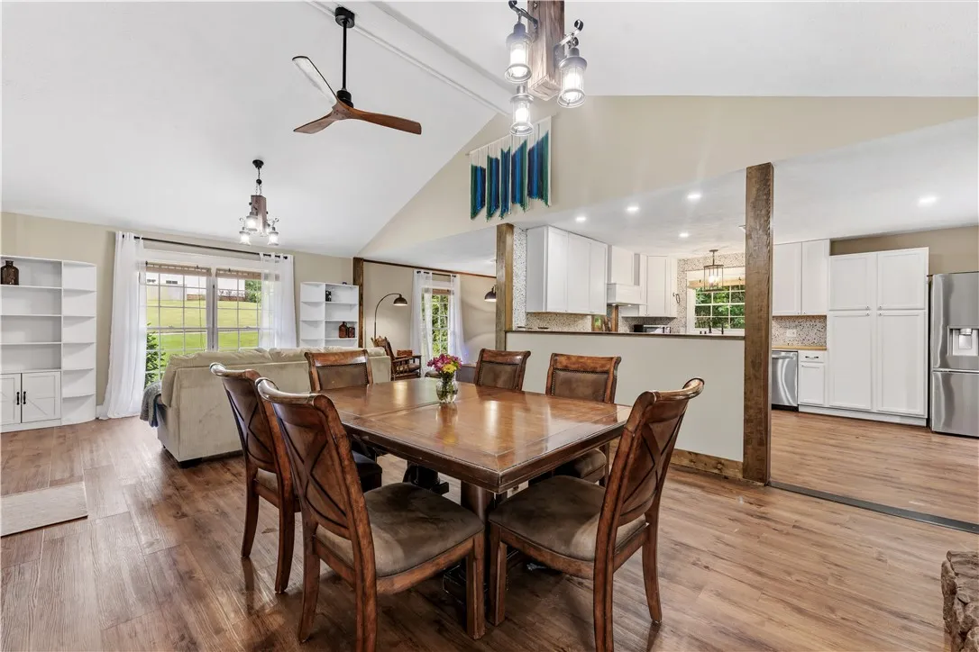 An open-concept living area features a dining space and a well-lit kitchen with a spacious layout.