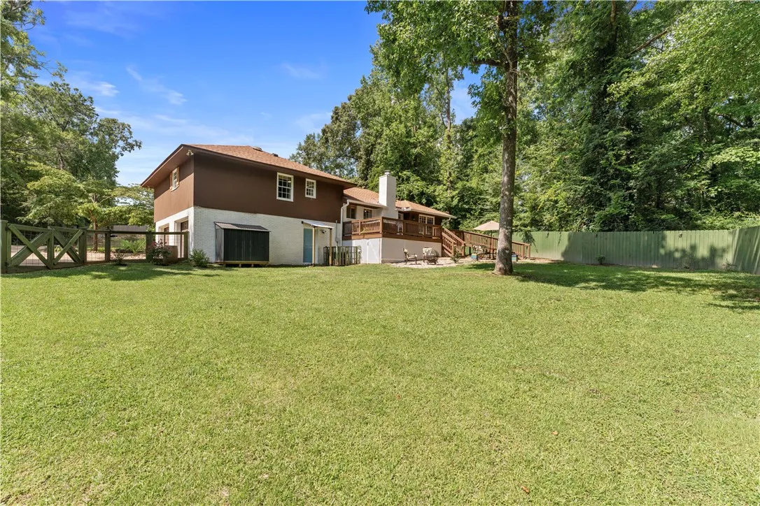 A spacious backyard with mature trees and a multi-level deck, perfect for outdoor enjoyment.