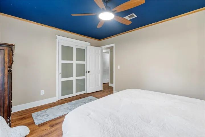A comforting retreat, this bedroom offers convenient closet access and rich wood flooring.