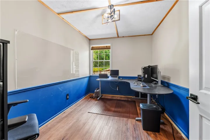 A dedicated home office space with rich wood flooring and a refreshing outdoor view.