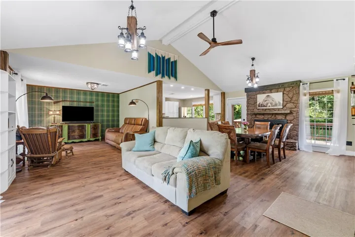 A spacious living area combines comfort and functionality with a striking stone fireplace and durable wood flooring.