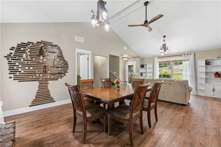 Natural wood flooring complements the rustic wall accent and ceiling details in this inviting dining area.