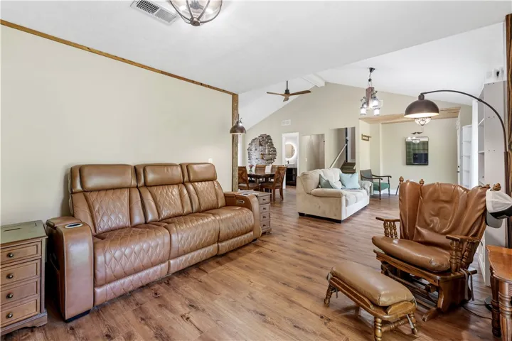 Natural wood flooring complements this inviting living area with vaulted ceilings and abundant space.