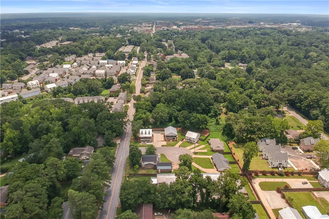 An aerial perspective reveals a vibrant neighborhood nestled among lush, mature trees and convenient roadways.