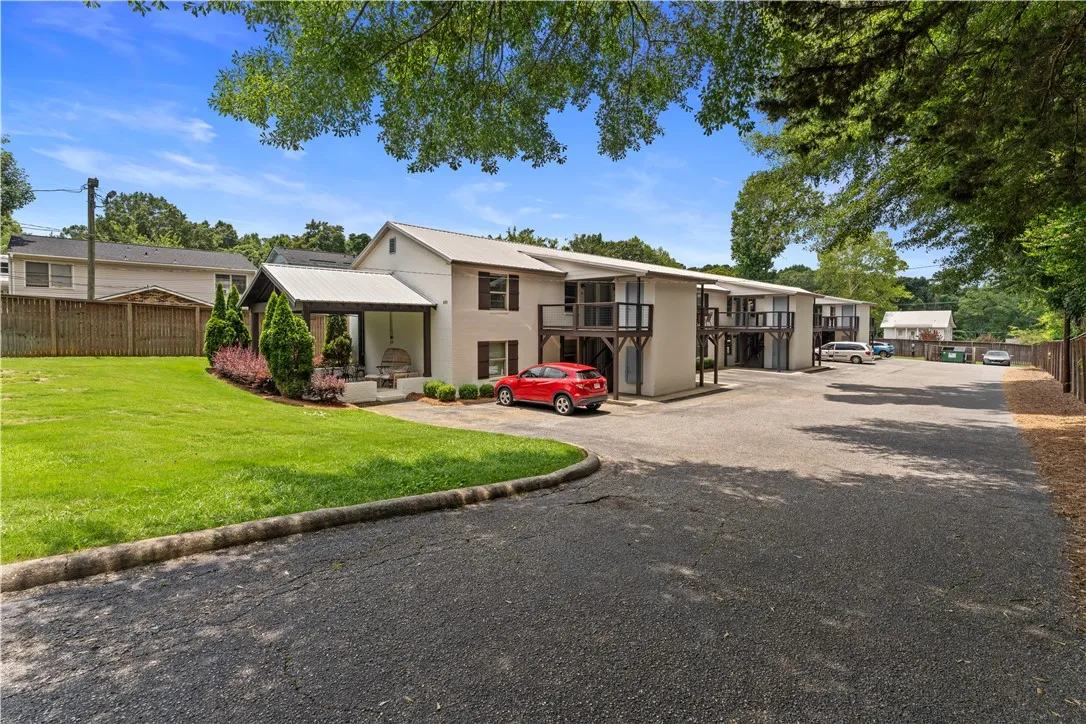 A neatly paved parking area complements this multi-unit building with exterior balconies.