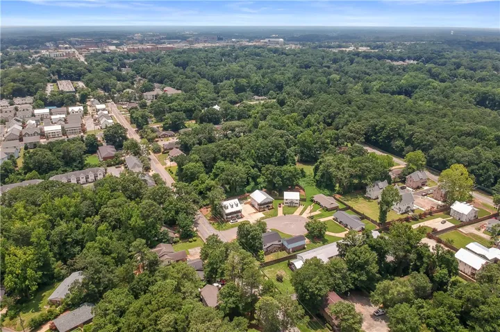An aerial perspective reveals a serene residential neighborhood enveloped by lush, mature trees and ample green spaces.