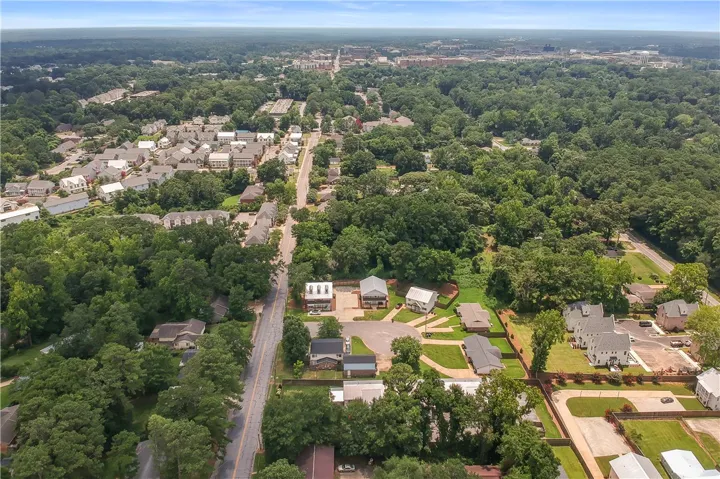 An aerial perspective reveals a vibrant neighborhood nestled among lush, mature trees and convenient roadways.
