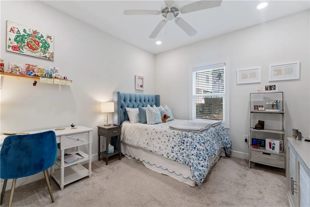 A comforting bedroom with neutral tones and a plush blue upholstered bed offers a peaceful retreat.
