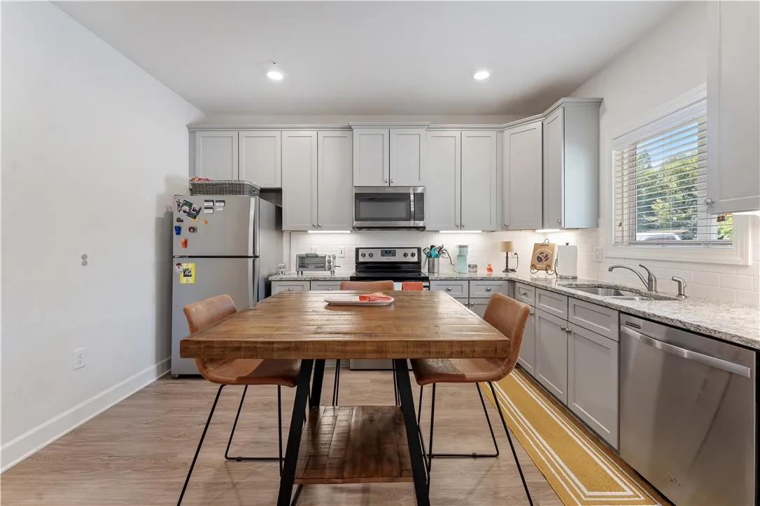 A well-appointed kitchen features stainless steel appliances, granite counters, and light-toned cabinetry.