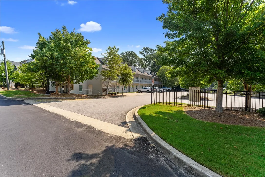 A welcoming entrance with a neatly kept fence and abundant greenery.