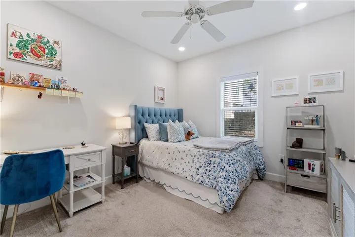 A comforting bedroom with neutral tones and a plush blue upholstered bed offers a peaceful retreat.