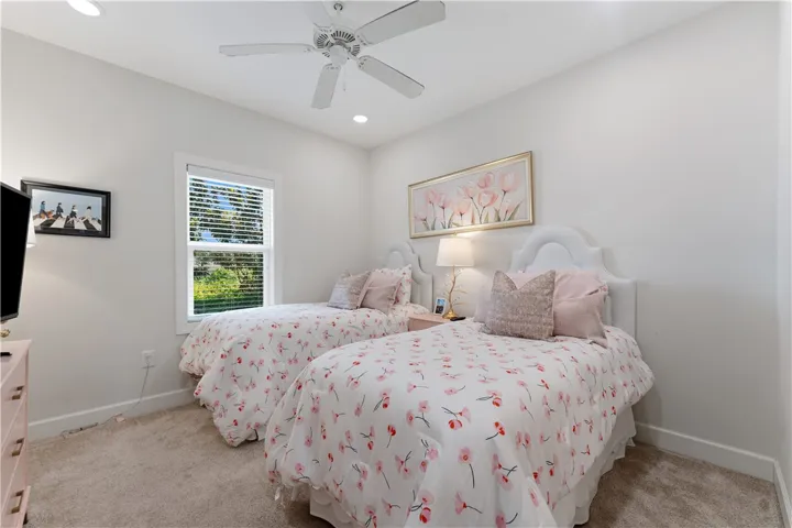 A comforting bedroom with twin beds and a window overlooks lush greenery, creating a peaceful retreat.