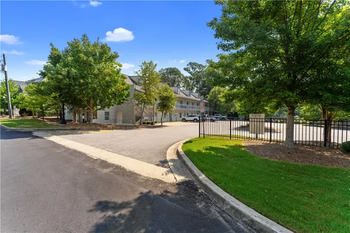 A welcoming entrance with a neatly kept fence and abundant greenery.