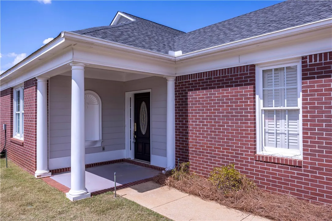 A welcoming brick and siding exterior with a covered porch beckons guests to this charming residence.