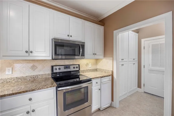 A well-appointed kitchen showcasing elegant white cabinetry and durable granite countertops.