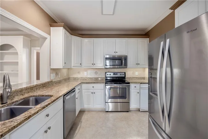Granite counters and stainless steel appliances complete this well-appointed kitchen.