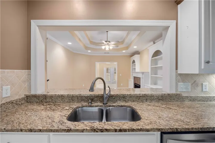 A chef's kitchen boasts granite counters and an open floorplan to the living area.