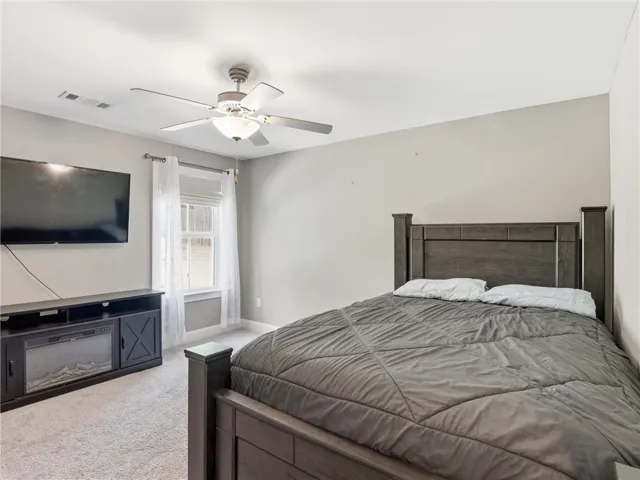 Well-lit sleeping quarters with plush carpeting and natural light filtering through window coverings.
