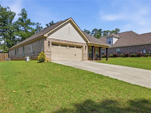 A classic brick exterior with a welcoming covered entry and an attached garage awaits.
