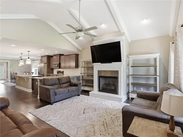 An inviting open-concept area where the kitchen seamlessly transitions into a comfortable living space with a fireplace.