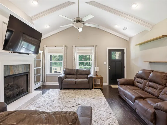 Vast ceilings elevate this living space, featuring rich hardwood floors and a striking stone fireplace.