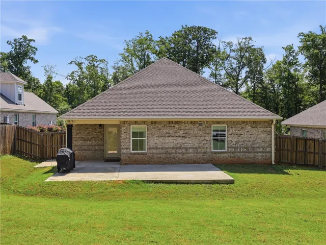 A well-maintained lawn provides a pleasant backdrop to the back of the brick residence.