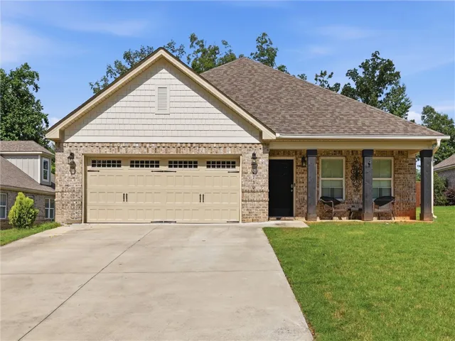 A welcoming brick and shingle exterior with a covered porch awaits at this charming residence.
