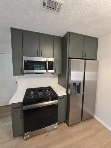 A well-appointed kitchen showcasing contemporary cabinetry, new appliances, and durable flooring.