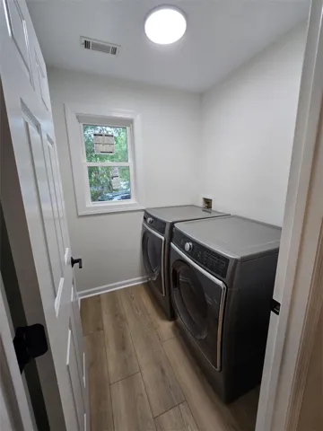 Functional laundry space featuring modern appliances and a window for natural light.