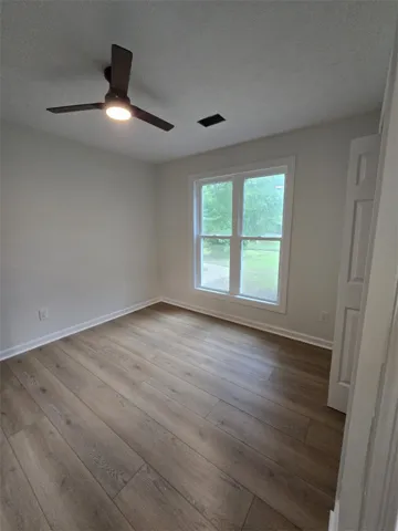 Hardwood-style flooring and a bright window create an inviting atmosphere in this functional room.