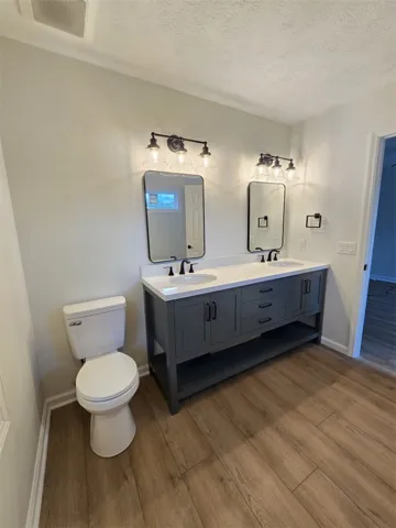 A well-appointed bathroom features a modern dual vanity with stylish mirrors and ample lighting.