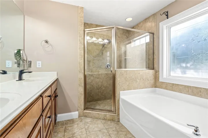 Indulge in a primary bathroom featuring a spacious walk-in shower and a separate soaking tub for ultimate relaxation.