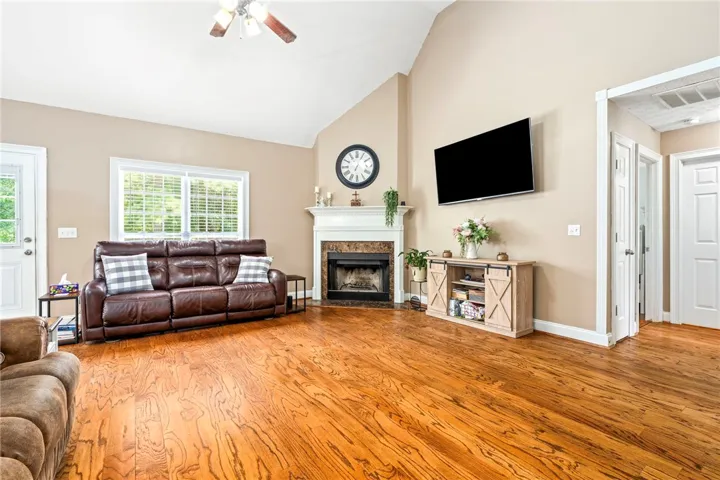 A welcoming living area showcases a beautiful fireplace and gleaming hardwood floors.