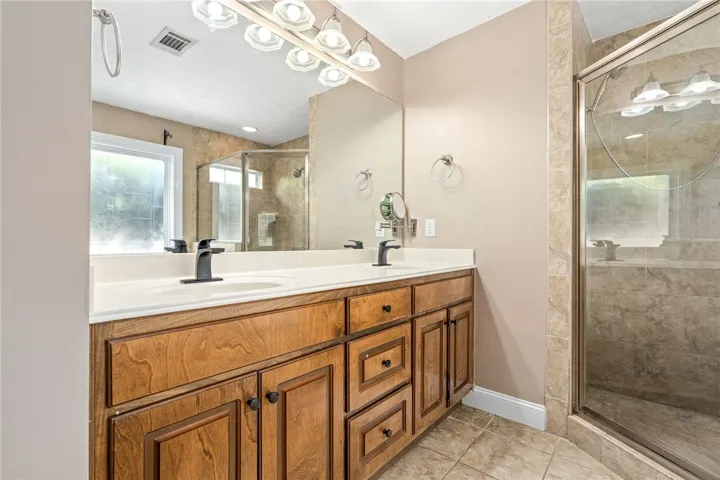 Double vanity and a spacious glass-enclosed shower create a practical bathroom retreat.