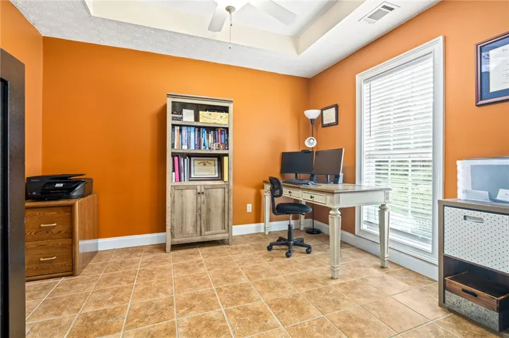A productive home office, featuring warm orange walls and durable tile flooring, ensures a comfortable workspace.