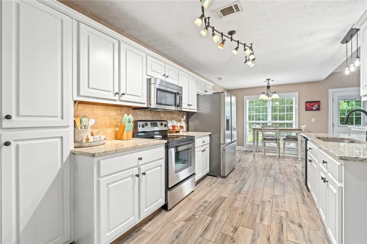 Culinary delights await in this bright kitchen, complete with stainless steel appliances and durable granite countertops.