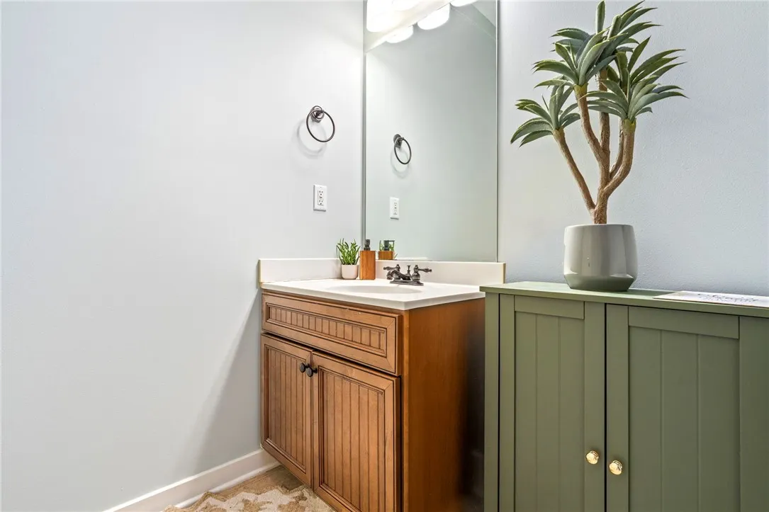 A well-appointed bathroom vanity features a mirror, sink, and storage cabinetry.