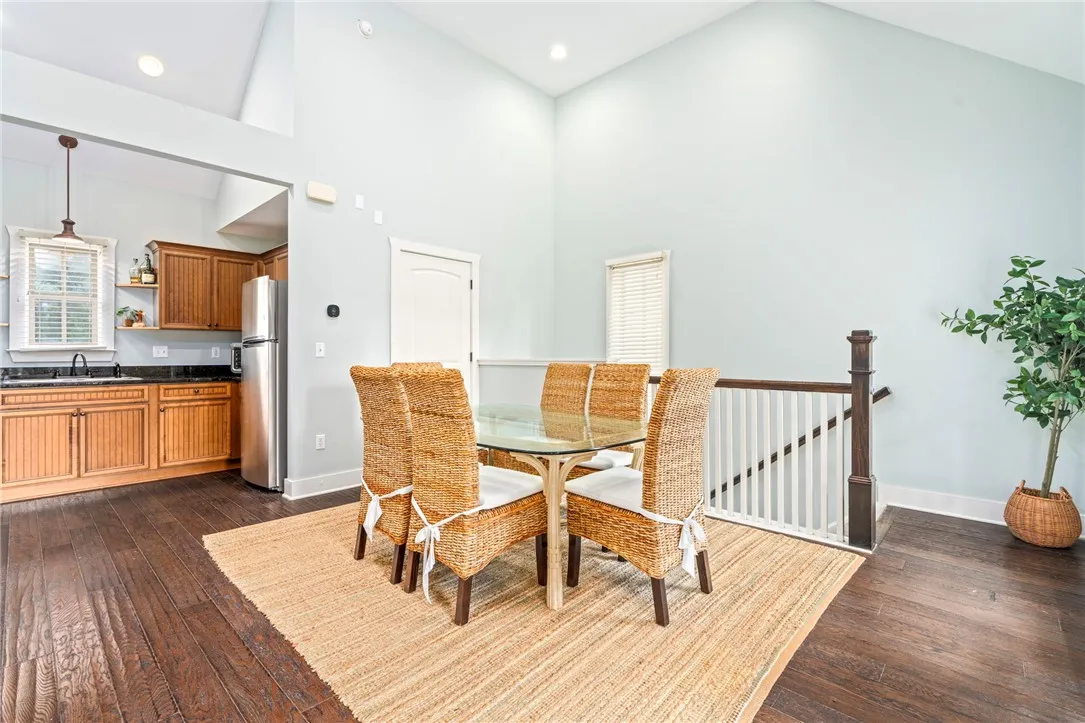 An open concept kitchen and dining area featuring high ceilings and rich wood flooring.